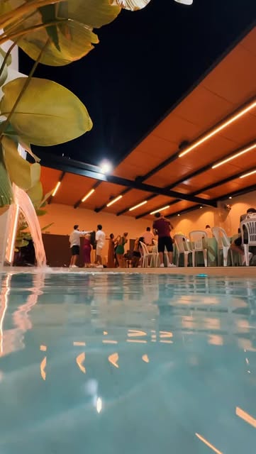 Publicação do Manancial mostrando a piscina iluminada durante um evento à noite